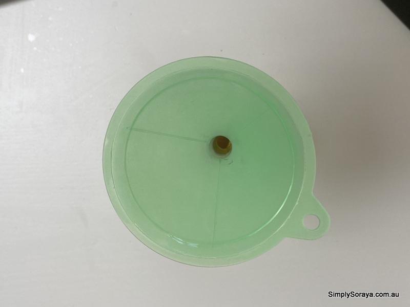 Pouring oil into funnel to place it in my amber bottle