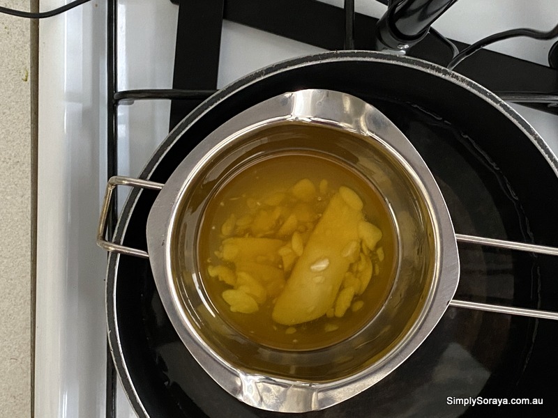 Melting and mixing the cocoa butter and sunflower oil in a double boiler to make bath melts