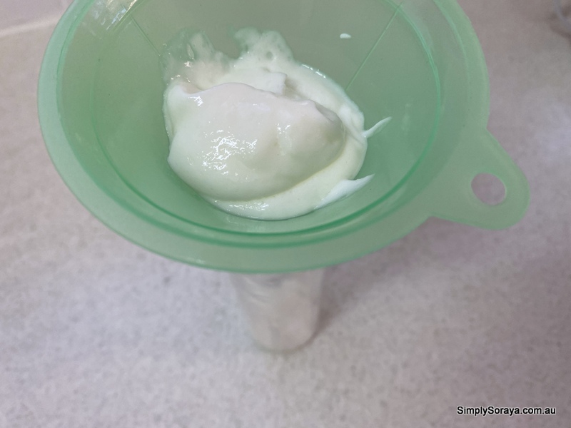 Using a funnel to get the new hand lotion into the pump bottle